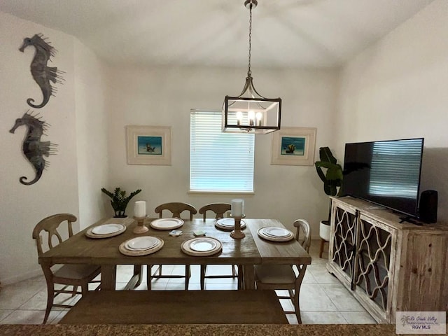 dining space featuring baseboards, light tile patterned flooring, and a notable chandelier