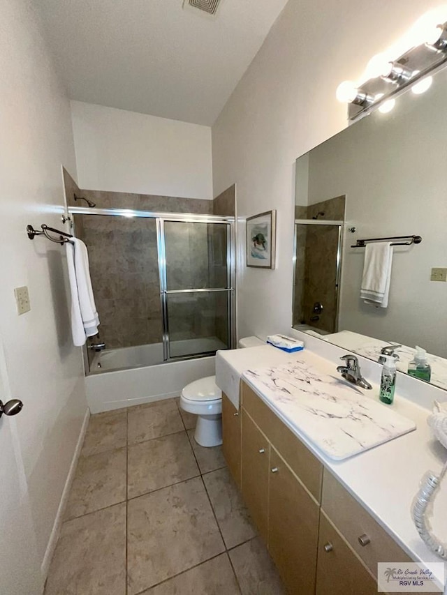 bathroom with visible vents, vanity, tile patterned floors, combined bath / shower with glass door, and toilet