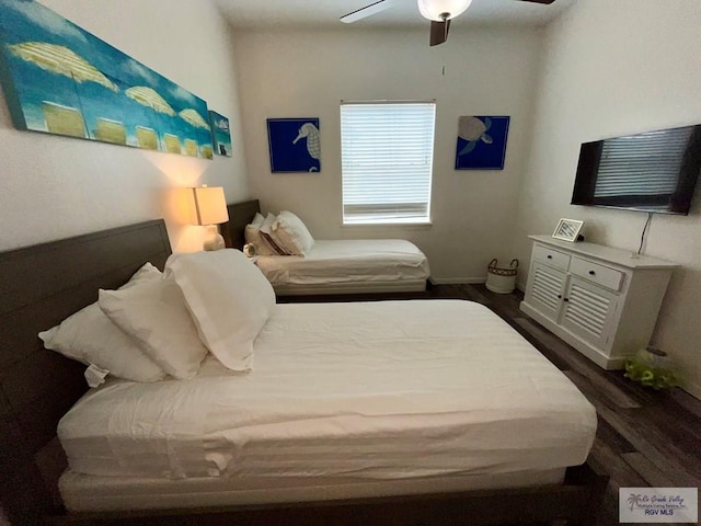 bedroom with a ceiling fan, baseboards, and wood finished floors