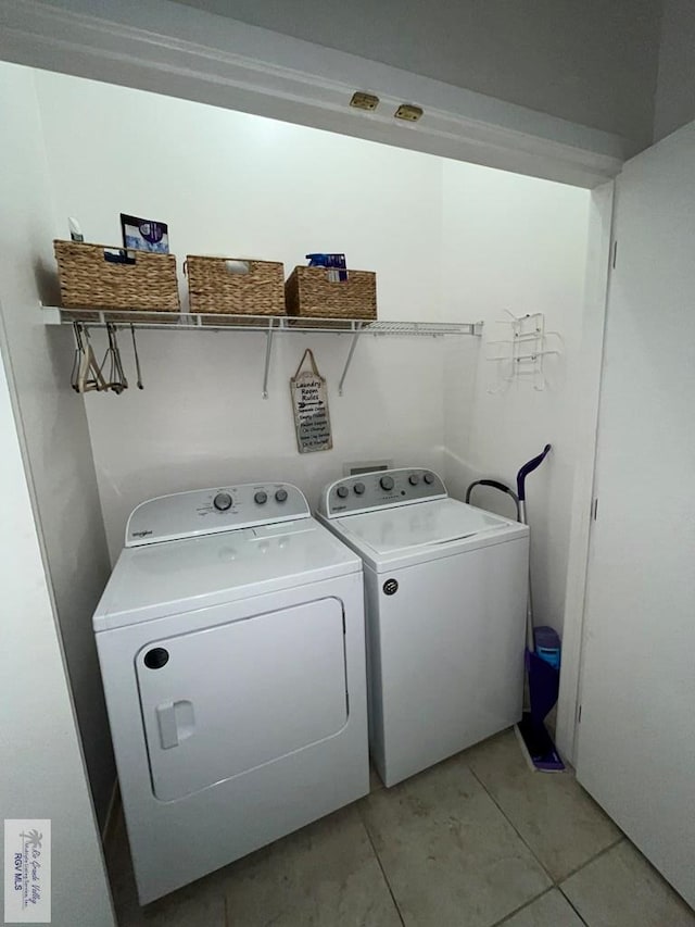 laundry room featuring light tile patterned floors, laundry area, and washing machine and clothes dryer