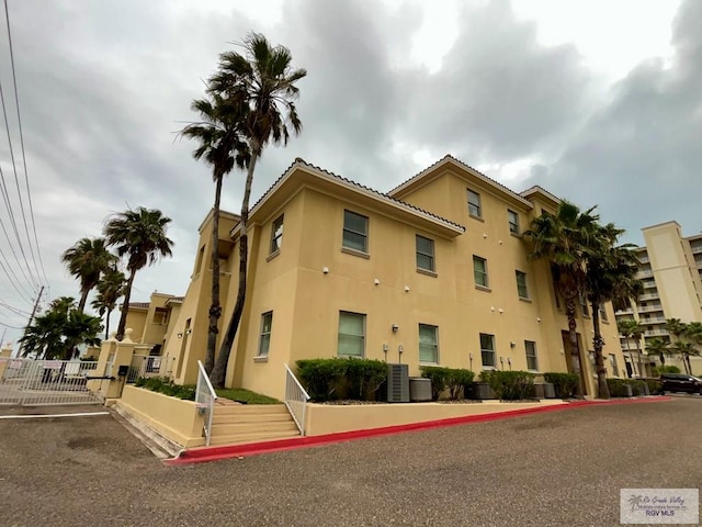 view of property featuring central air condition unit and fence