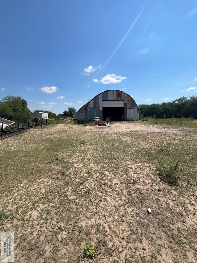 view of yard with a rural view and an outdoor structure