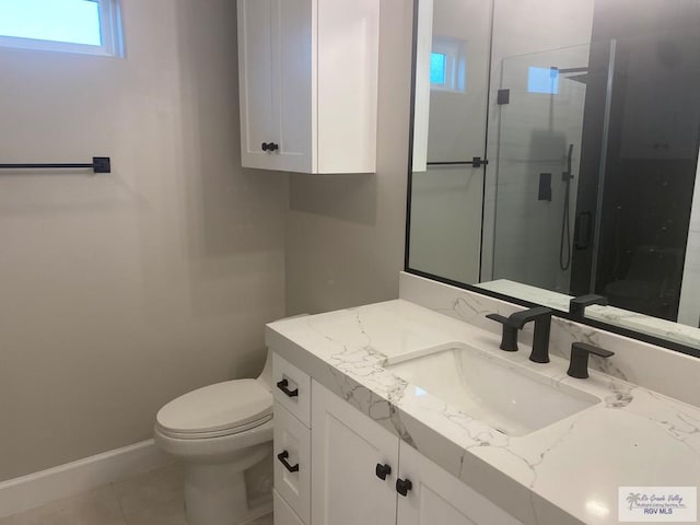 bathroom with toilet, vanity, tile patterned floors, and a shower with shower door