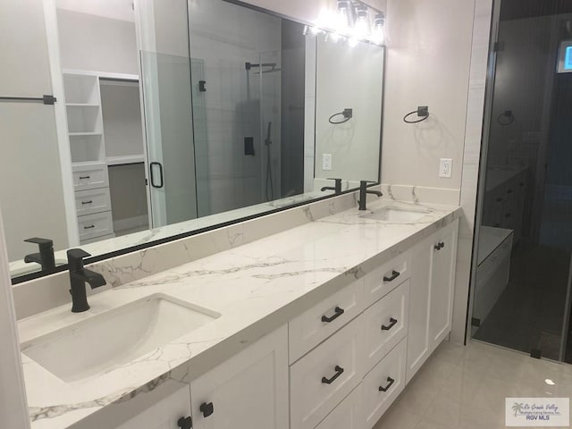 bathroom featuring tile patterned flooring, walk in shower, and vanity