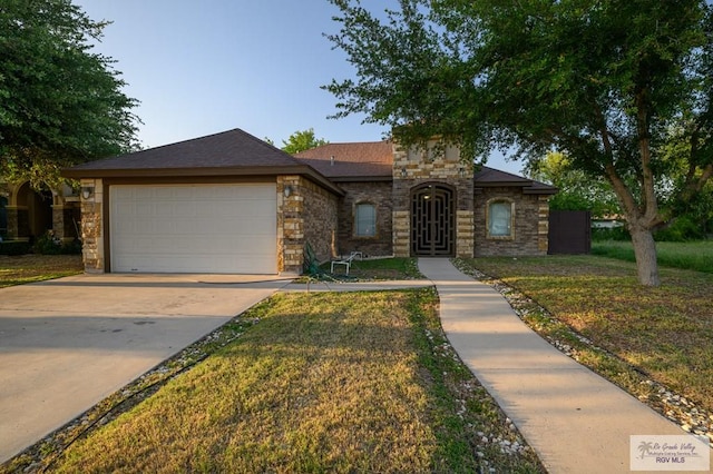 1508 W 20th St, Mission, TX 78572 - view of front of house with an attached garage, stone siding, concrete driveway, and a front yard