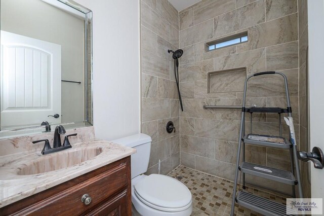 1508 W 20th St, Mission, TX 78572 - bathroom featuring a tile shower, toilet, and vanity