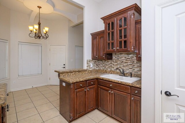 1508 W 20th St, Mission, TX 78572 - kitchen featuring a sink, a chandelier, backsplash, hanging light fixtures, and glass insert cabinets