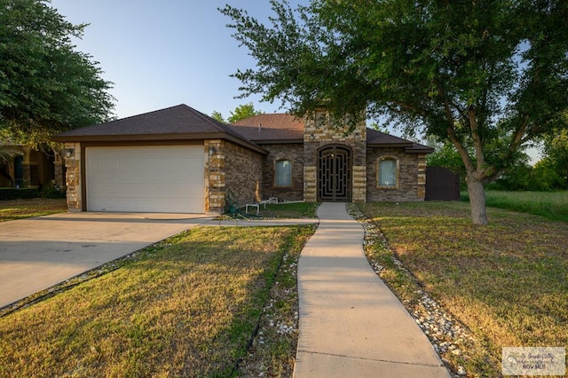 1508 W 20th St, Mission, TX 78572 - view of front of house featuring stone siding, an attached garage, concrete driveway, and a front lawn