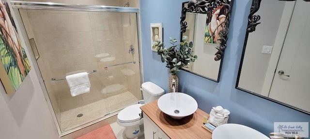 bathroom featuring vanity, a shower with shower door, and toilet