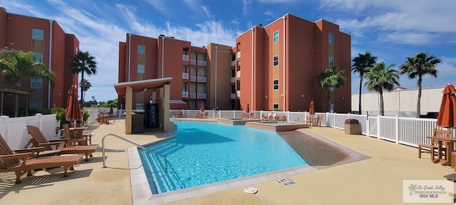 view of swimming pool with a patio area and a hot tub