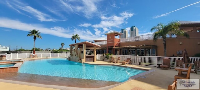 view of pool with a patio area and a hot tub