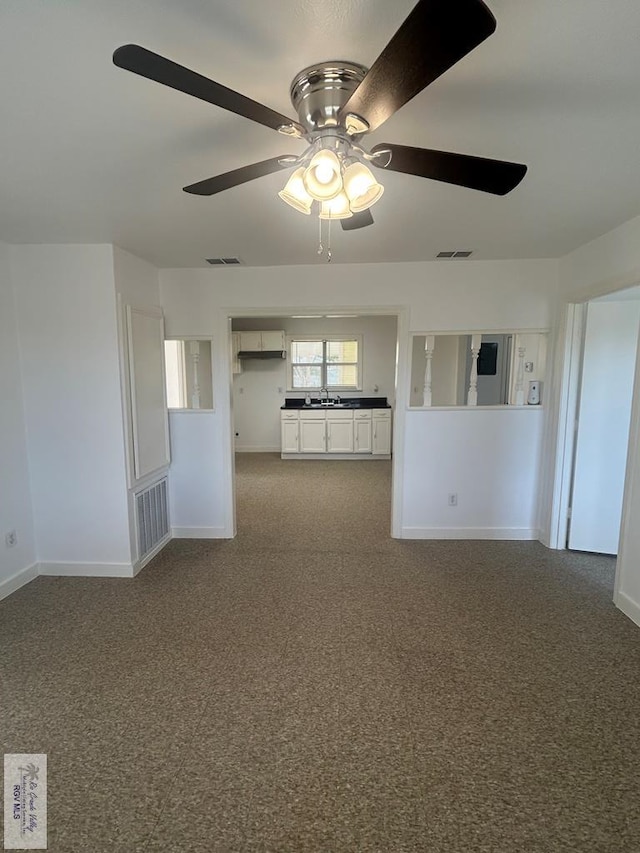 carpeted spare room featuring sink and ceiling fan