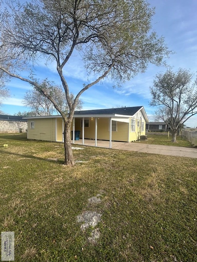 back of house featuring a carport and a yard