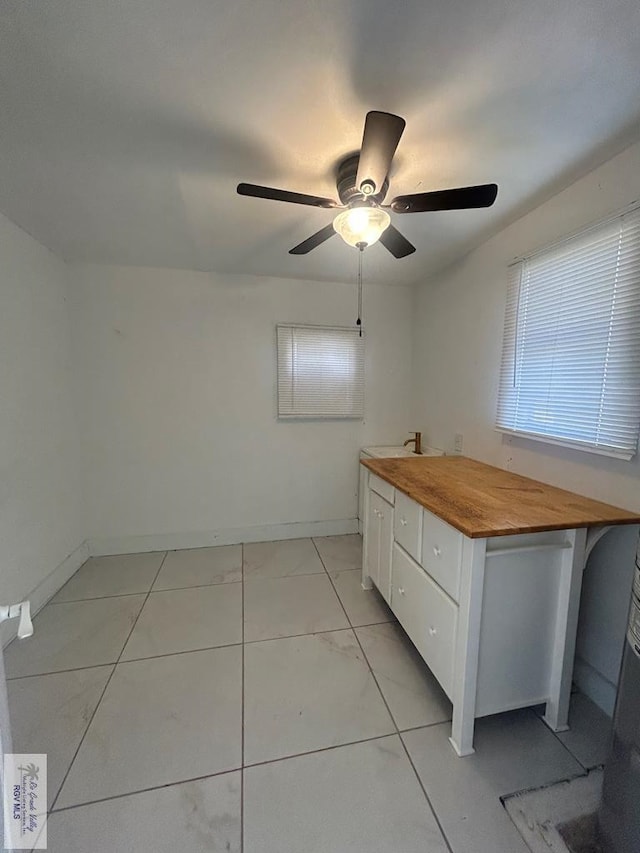 interior space featuring light tile patterned floors and ceiling fan