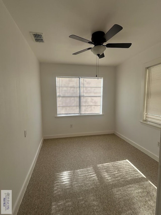 carpeted empty room with ceiling fan and a wealth of natural light