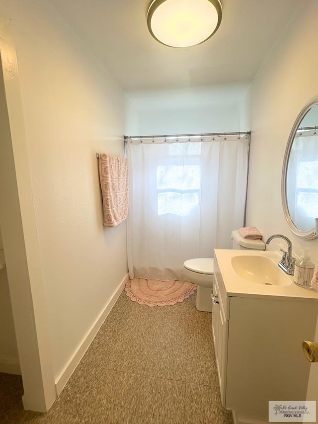 bathroom with vanity, curtained shower, and toilet