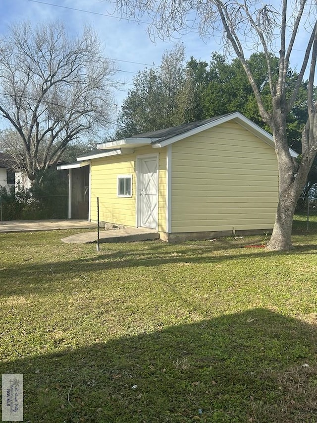 view of outdoor structure featuring a carport and a yard