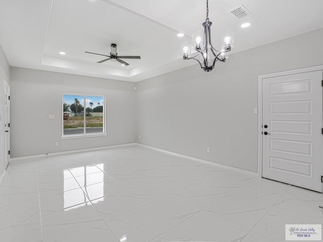 spare room featuring ceiling fan with notable chandelier and a raised ceiling