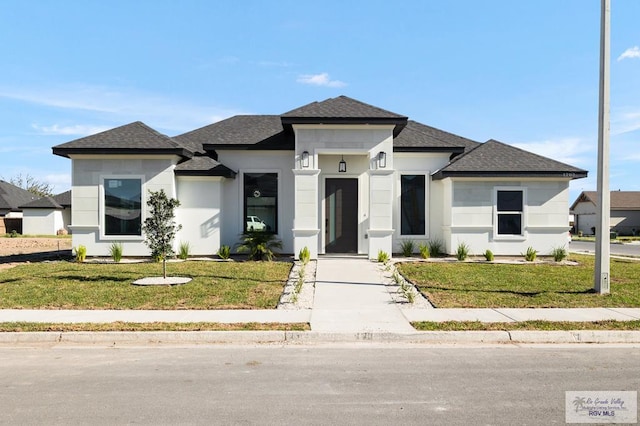 1202 Moses Dr, San Juan, TX 78589 - prairie-style home featuring roof with shingles, stucco siding, and a front yard