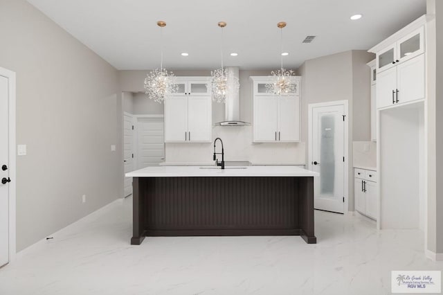 1202 Moses Dr, San Juan, TX 78589 - kitchen featuring a sink, a kitchen island with sink, a chandelier, marble finish floor, and wall chimney exhaust hood