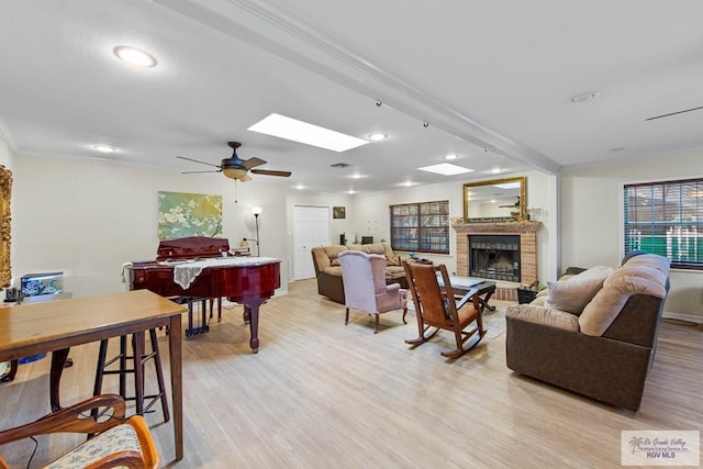 living room featuring ceiling fan, a brick fireplace, billiards, crown molding, and light hardwood / wood-style floors