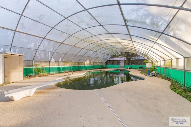 view of pool with a diving board and a patio