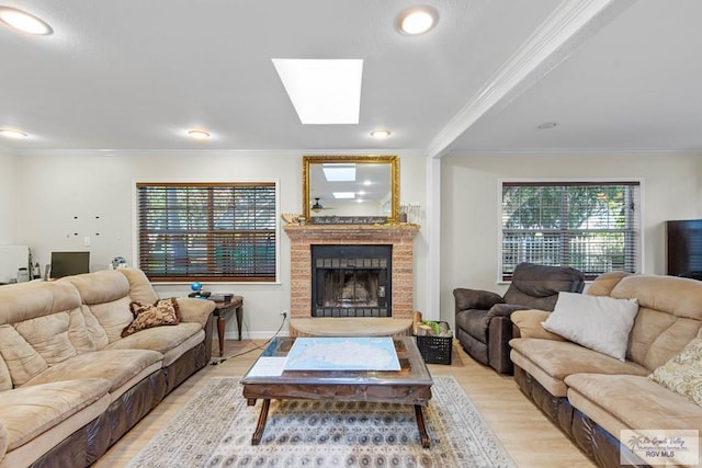 living room featuring light hardwood / wood-style flooring, crown molding, and a skylight