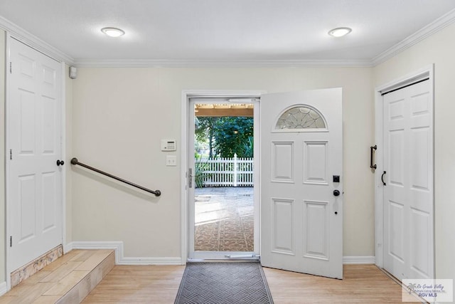 entryway featuring light wood-type flooring and ornamental molding