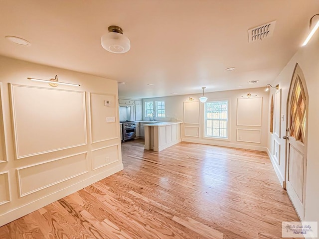1214 W Lincoln Ave Unit 22, Harlingen, TX 78550 - unfurnished living room with a decorative wall and light wood-style floors
