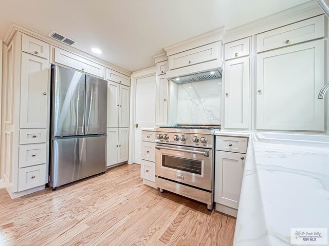 1214 W Lincoln Ave Unit 22, Harlingen, TX 78550 - kitchen featuring appliances with stainless steel finishes, premium range hood, light wood-style flooring, and recessed lighting