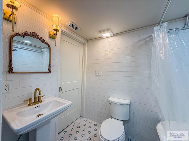 1214 W Lincoln Ave Unit 22, Harlingen, TX 78550 - bathroom featuring tile walls, toilet, curtained shower, and a sink