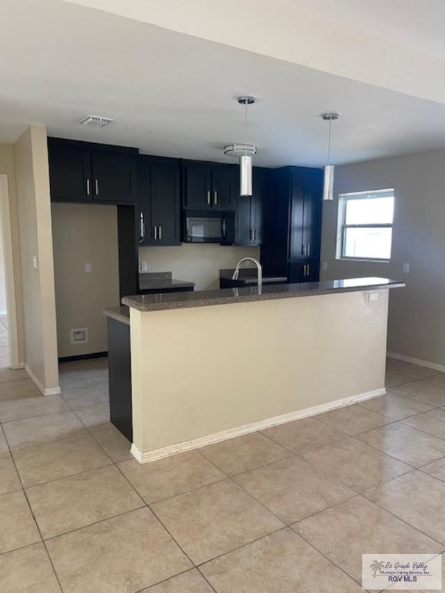 kitchen featuring sink, light tile patterned floors, and decorative light fixtures