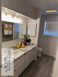 bathroom featuring vanity, hardwood / wood-style floors, and toilet