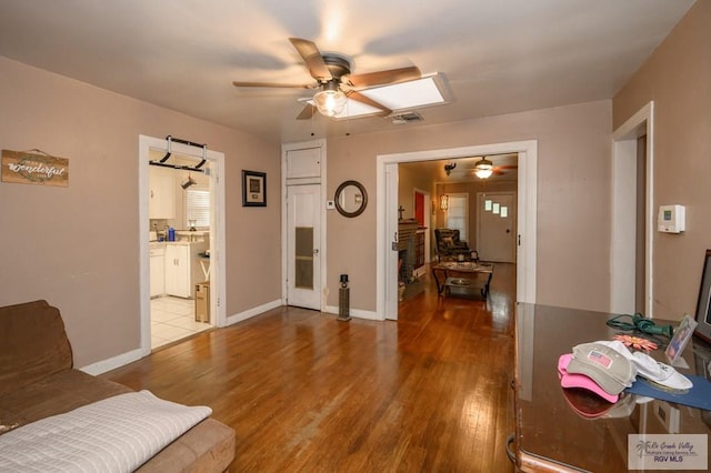 living room with light wood-type flooring and ceiling fan