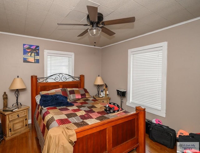 bedroom with ceiling fan, hardwood / wood-style floors, and crown molding