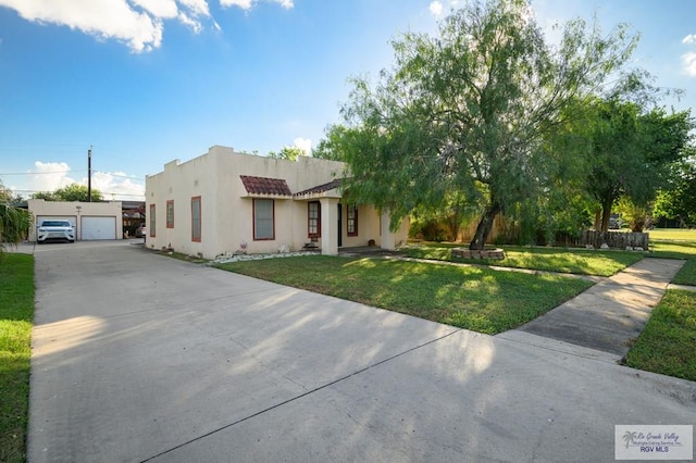 view of front facade with a garage, an outdoor structure, and a front yard