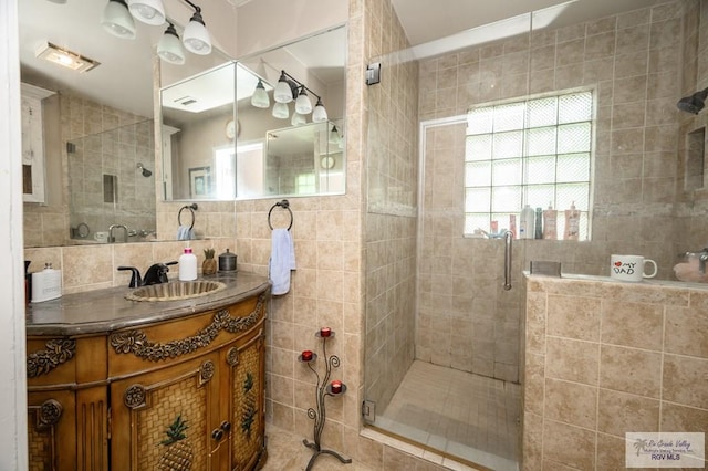 bathroom featuring backsplash, vanity, walk in shower, and tile walls