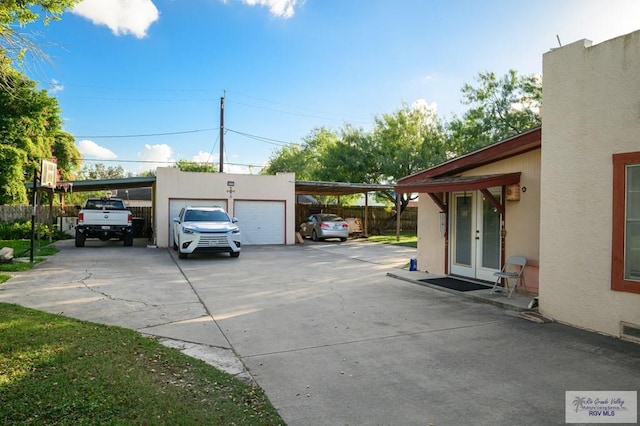 view of parking / parking lot featuring french doors and a carport