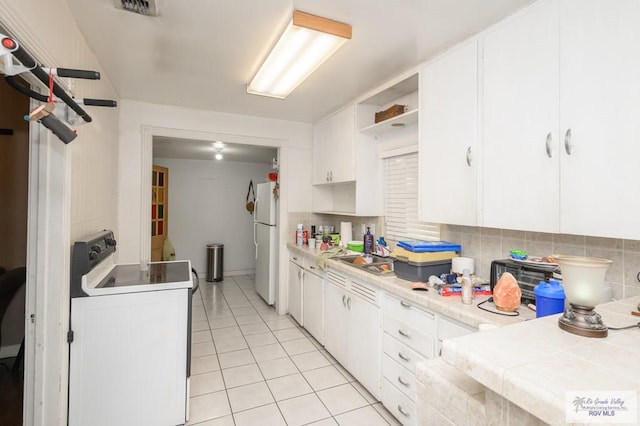 kitchen featuring backsplash, washer / clothes dryer, white cabinetry, and white appliances