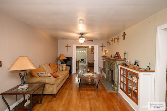 living room with wood-type flooring and ceiling fan