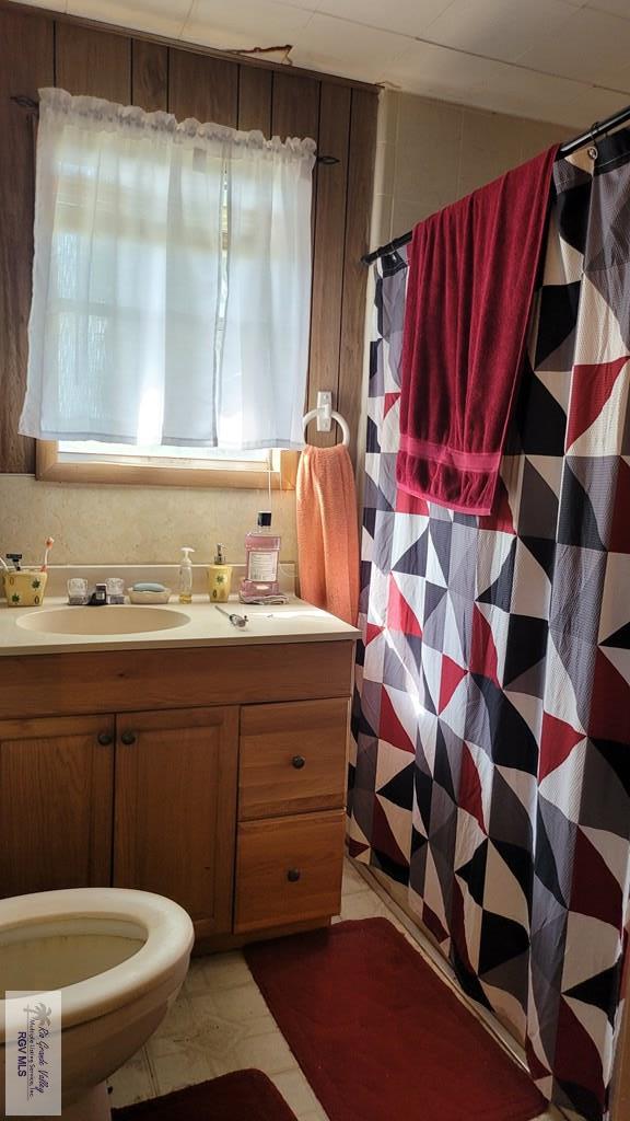 bathroom with tile patterned flooring, vanity, and toilet