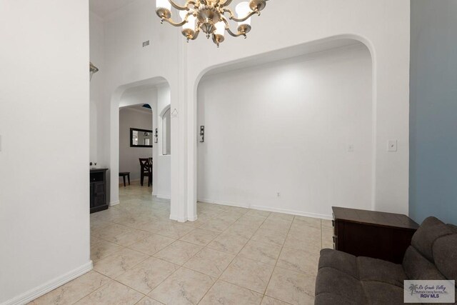 interior space featuring a towering ceiling and a notable chandelier