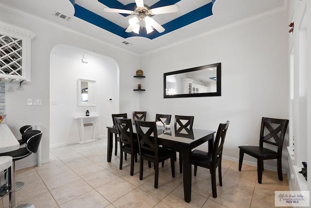 tiled dining area featuring ceiling fan and crown molding