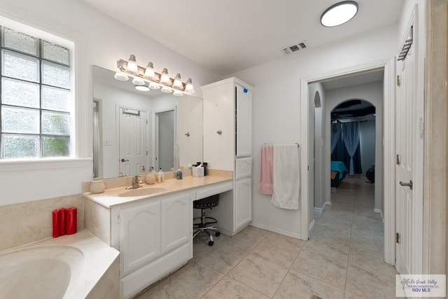 bathroom with tile patterned floors, vanity, and a tub to relax in