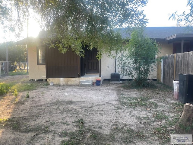 back of property featuring fence and central AC