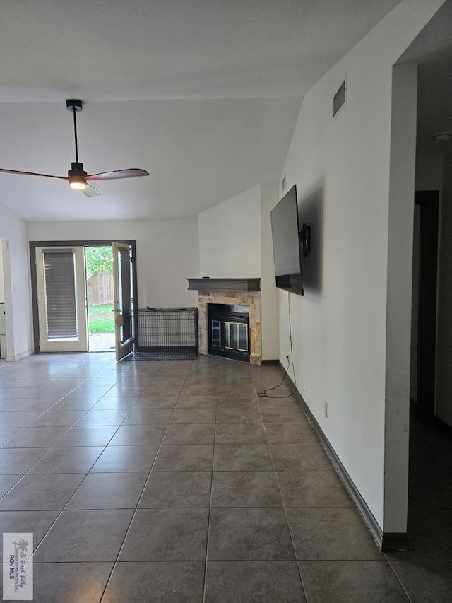 4727 Las Palomas St, Brownsville, TX 78521 - unfurnished living room featuring a glass covered fireplace, lofted ceiling, ceiling fan, and dark tile patterned floors