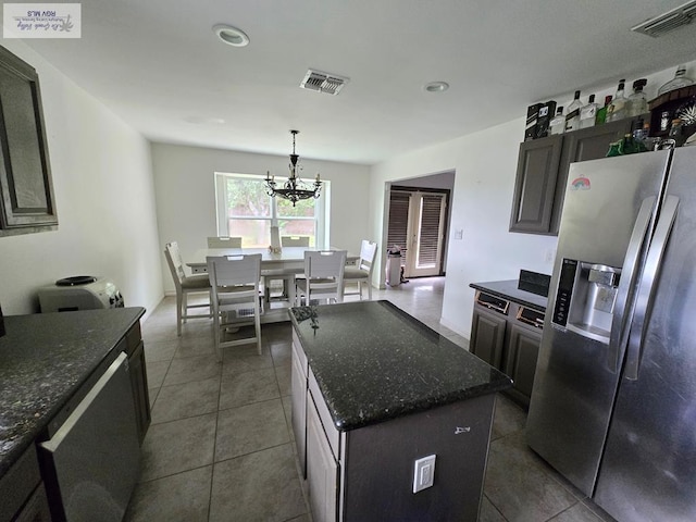 4727 Las Palomas St, Brownsville, TX 78521 - kitchen featuring stainless steel refrigerator with ice dispenser, a chandelier, dark tile patterned floors, a center island, and dark stone counters