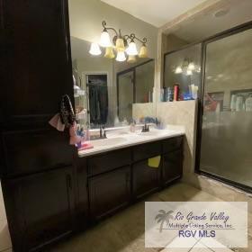 bathroom with vanity and a shower with door