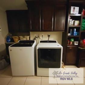 laundry area featuring washer and dryer, cabinets, and light tile patterned floors