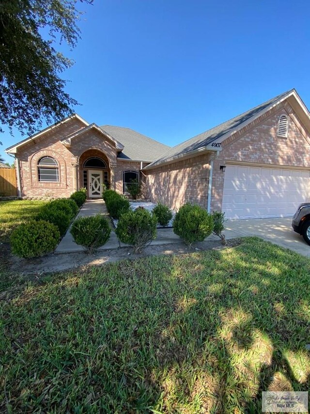 ranch-style home with a garage and a front lawn